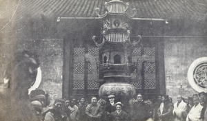 George Johnson, among others, beside an incense burner at an unidentified temple