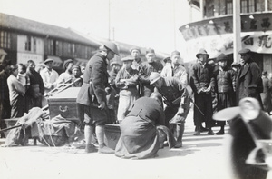 Vietnamese (Annamite) French police officer and a soldier inspecting the contents of a trunk, Shanghai