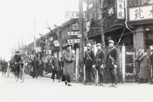 Three French army soldiers on guard at a barbed wire barricade, Shanghai