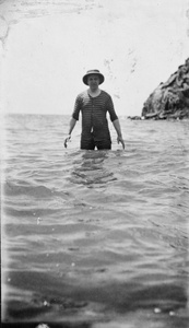 Reginald Hedgeland in the sea at Qinhuangdao, wearing a pith helmet