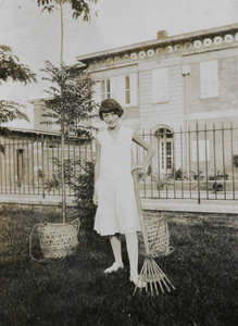 A woman in a garden with rake and baskets, Swatow