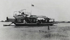 A junk berthed by a boat flying the red ensign, during floods at Nanning