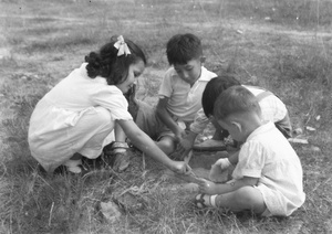 Kristine Thoresen, Jim Hutchinson, an unidentified child, and George Kulstand, playing near the Army Sports Ground, Mongkok, Hong Kong