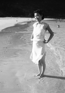 Unidentified woman, standing barefoot on a beach, Hong Kong