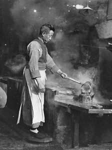 A man filling a kettle in a hot water shop (old tiger stove shop or laohuzao), Shanghai