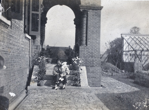 Amah holding a baby and seated on entrance steps 35 Tongshan Road, Hongkou, Shanghai