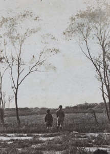 Fred and Dick Hutchinson looking over a field towards grave mounds, Hongkou, Shanghai