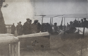 Katherine Stinson with crew, reporters, and soldiers around her airplane, Jiangwan airfield, Shanghai