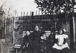 Dick, Fred, Harry and Maggie Hutchinson, with an older Chinese woman, on a garden bench, 35 Tongshan Road, Hongkew, Shanghai