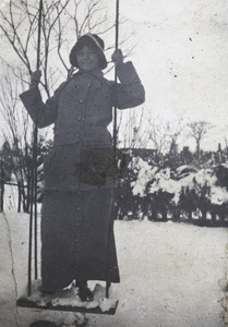 Young woman standing on a swing in the snowy garden of 35 Tongshan Road, Hongkou, Shanghai