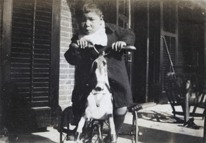 Fred Hutchinson sitting on a hobby horse tricycle, 35 Tongshan Road, Hongkou, Shanghai