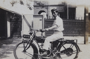 Tom Hutchinson on a motorbike in the street outside 35 Tongshan Road, Hongkou, Shanghai