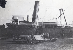 A cargo ship and smaller boats on the Huangpu River, Shanghai