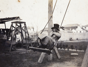 Young woman crouching on a swing in the garden of 35 Tongshan Road, Hongkou Shanghai