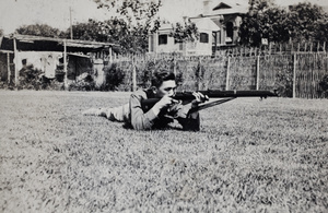 Bill Hutchinson aiming a rifle, 35 Tongshan Road, Hongkou, Shanghai