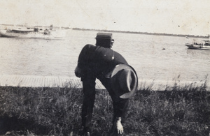 John Piry bending forward while carrying a camera, Wusong, near Shanghai