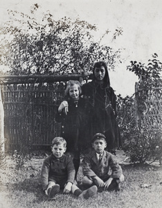 Maggie and Fred Hutchinson in the garden with neighbouring girl and boy, 35 Tongshan Road, Hongkou, Shanghai