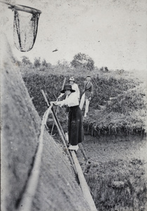 Woman crossing a makeshift bamboo bridge to a fishing drop-net station, near Shanghai