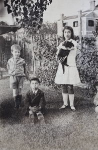 Maggie and Fred Hutchinson in the garden with neighbouring boy, 35 Tongshan Road, Hongkou, Shanghai