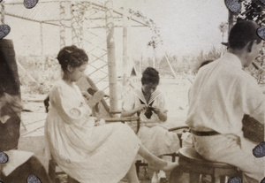 Two women doing needlework in the garden of T. J. Roche, Shanghai