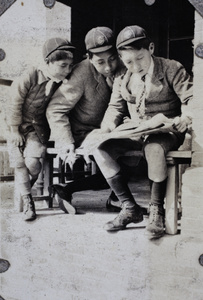 Fred, Harry and Dick Hutchinson reading a ""Jiggs"" comic strip, 35 Tongshan Road, Hongkou, Shanghai