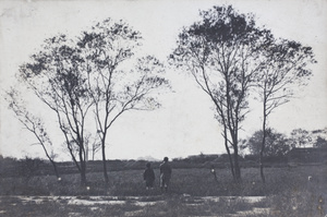 Fred and Dick Hutchinson looking over a field towards grave mounds, Hongkou, Shanghai