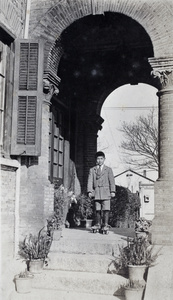 Fred Hutchinson wearing roller skates and standing in the entrance porch to 35 Tongshan Road, Hongkou, Shangahai