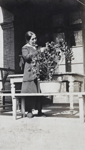 Elizabeth Hutchinson inspecting a citrus fruit tree growing in a pot, 35 Tongshan Road, Hongkou, Shanghai