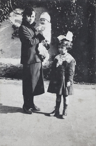 Young woman, holding a baby, with a young girl, Shanghai