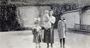 Young woman, holding a baby, with two young girls, Shanghai