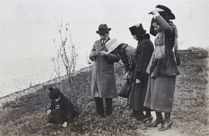 Bill Hutchinson whittling a stick while on a day out with four women, Shanghai