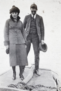 Unidentified young woman and Bill Hutchinson standing aboard a river boat, Shanghai