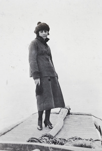 Unidentified young woman standing aboard a river boat, Shanghai