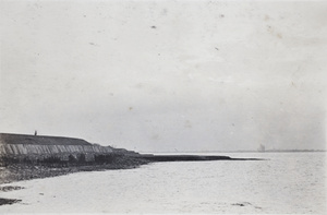 Person standing on a finger of land leading to a jetty, near Shanghai