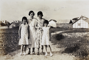 Bea and Gladys Hutchinson, wearing dresses made from the same fabric, with two unidentified women, Roselawn Dairy Farm in the background, Hongkou, Shanghai