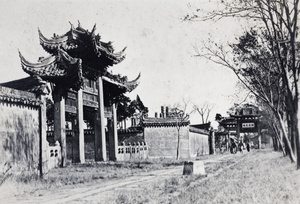 Ornate pailou and a roadside mounting block