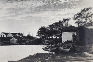 A wooden jetty, an embankment of large tree trunks and waterside buildings