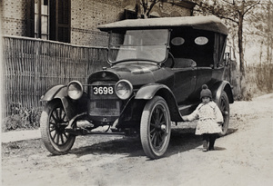 Bea Hutchinson standing in Tongshan Road beside the car of her uncle, Charles Hutchinson, Hongkou, Shanghai