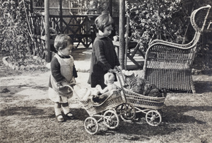 Gladys and Bea Hutchinson with toy prams near the garden summer house, 35 Tongshan Road, Hongkou, Shanghai