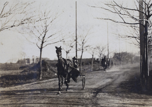 A horse and single-seat carriage followed by a horse and rider, Tongshan Road, Hongkou, Shanghai