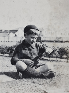A boy holding an object in the garden, 35 Tongshan Road, Hongkou, Shanghai
