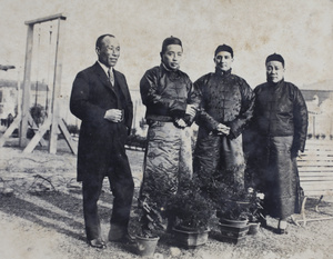 Charles Hutchinson wearing Chinese clothing with three unidentified men in the garden, 35 Tongshan Road, Hongkou, Shanghai