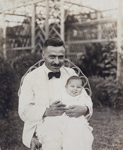 Unidentified man and baby in the garden, 35 Tongshan Road, Hongkou, Shanghai