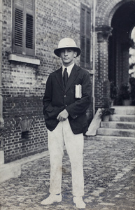 John Piry wearing a pith helmet and holding a Zane Grey novel, 35 Tongshan Road, Hongkou, Shanghai