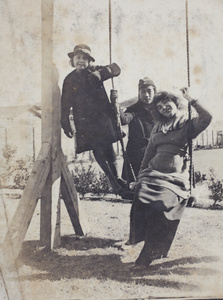 Maggie Hutchinson with Nora and Mrs Koskey on a garden swing, 35 Tongshan Road, Hongkou, Shanghai