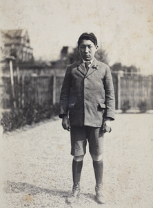 Dick Hutchinson, wearing school uniform, standing in the garden, 35 Tongshan Road, Hongkou, Shanghai
