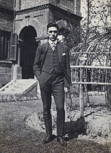 Bill Hutchinson wearing a pin-stripe suit and standing beside the garden rose frame, 35 Tongshan Road, Hongkou, Shanghai