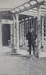 Tom Hutchinson standing in a park pergola with Doric-style columns, Shanghai