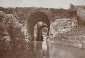 River barge passing passing through two arches of an old water gate