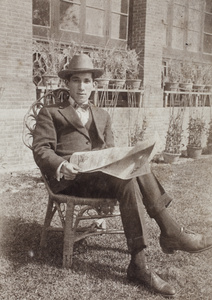 John Henderson reading a newspaper in the garden of 35 Tongshan Road, Hongkou, Shanghai